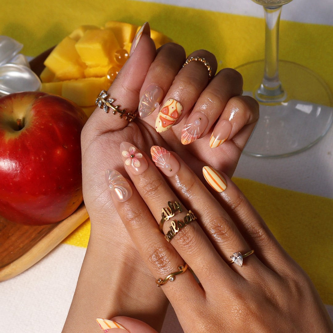 Handmade summer press-on nails with peach base, orange stripes, hand-painted bikini, pink starfish and iridescent seashell shimmer by Lily Nails Art