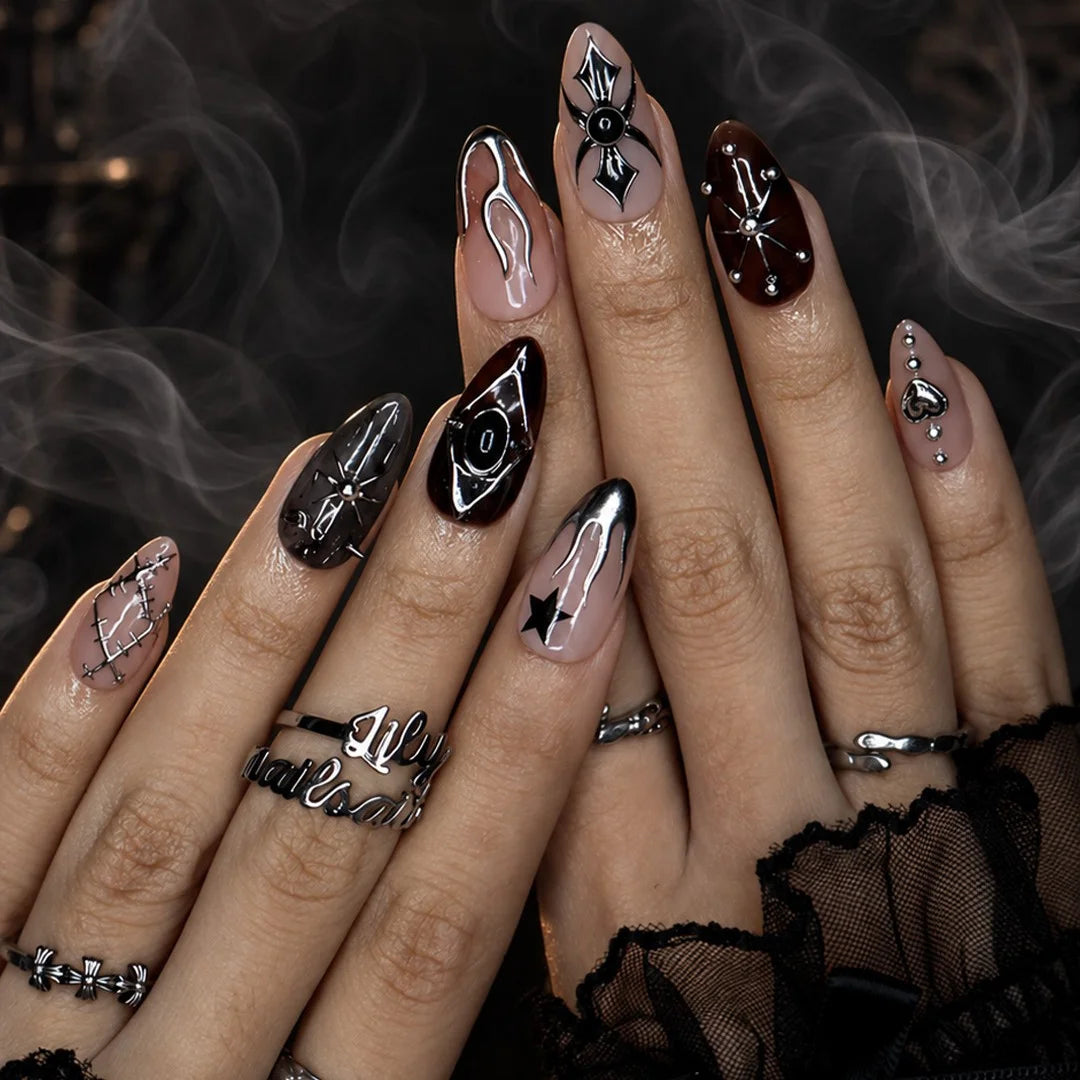 Séance gothic press on nails in nude, tortoiseshell brown and black with chrome silver flames, a 3D spider, ornate cameo, stars, heart charm and stitched details — handmade Halloween press on nails, medium almond fake nails and occult gothic nail art.