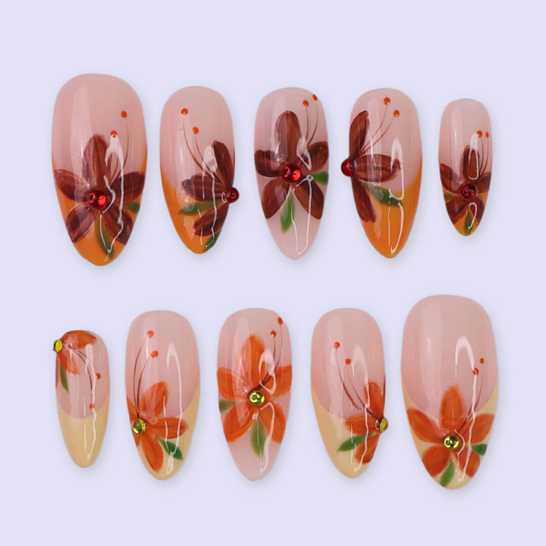 Autumn floral press on nails with hand-painted orange and red flowers, gem accents, and nude-to-warm gradient bases — custom made medium almond nails, reusable luxury nail art — perfect for fall, autumn looks, or romantic seasonal style.