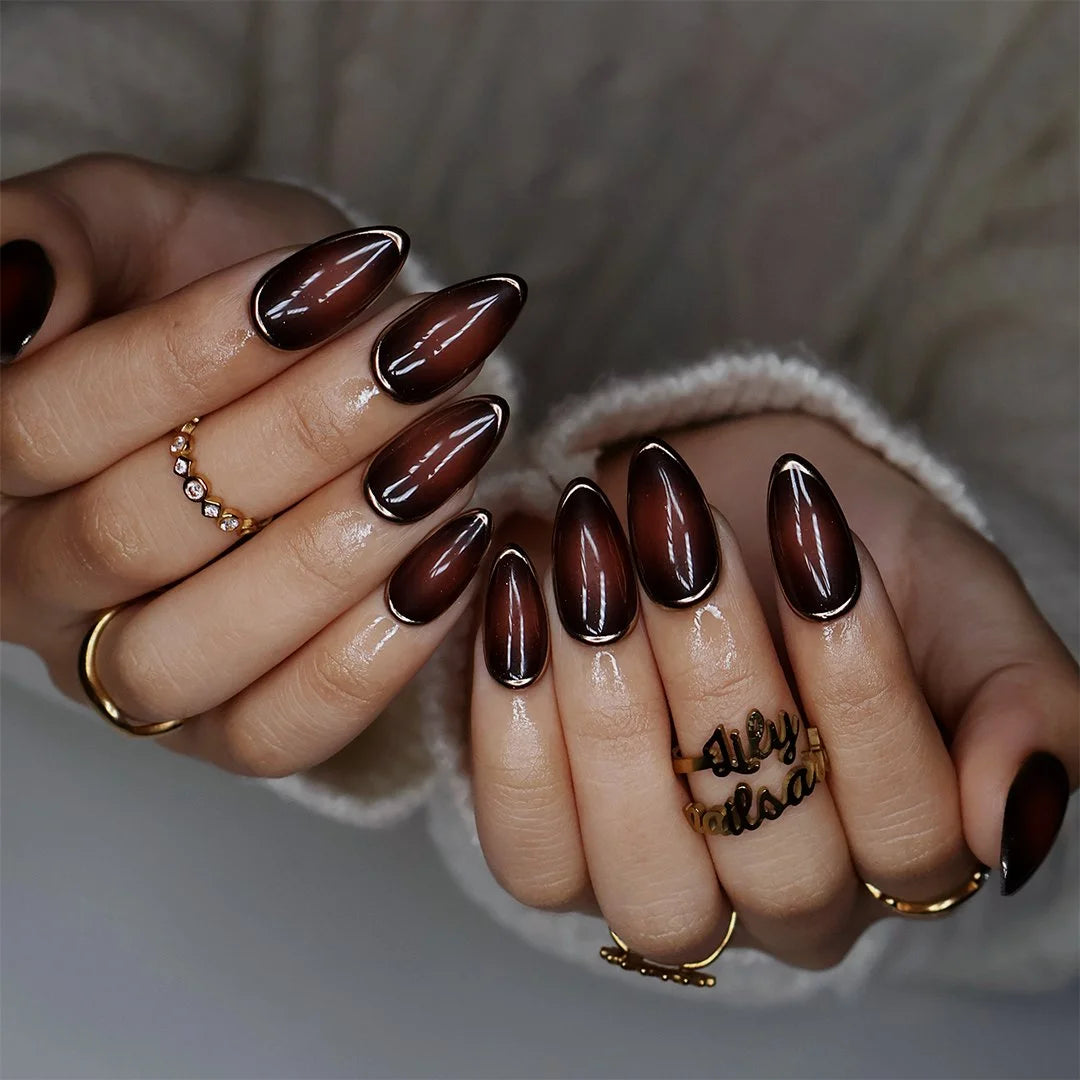 Espresso handmade fall press-on nails — almond set in glossy translucent chocolate-brown with liquid gold chrome mirror borders and a minimalist luxury finish