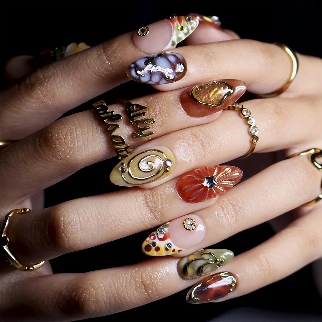 Close-up of marble, agate and starburst gem detail on almond nails