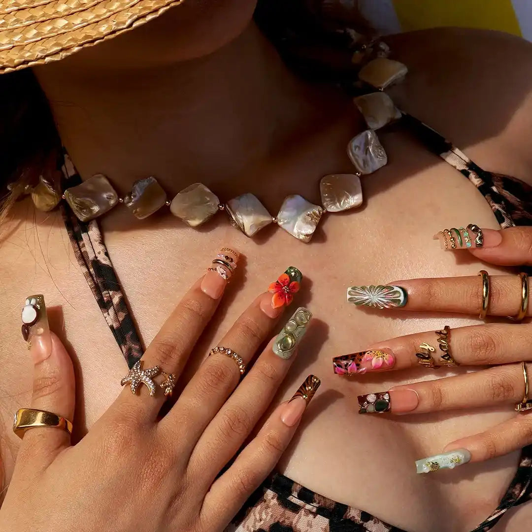 Handmade luxury summer press-on nails with tropical hibiscus, coconut art, 3D floral centerpiece and gold chain embellishments by Lily Nails Art