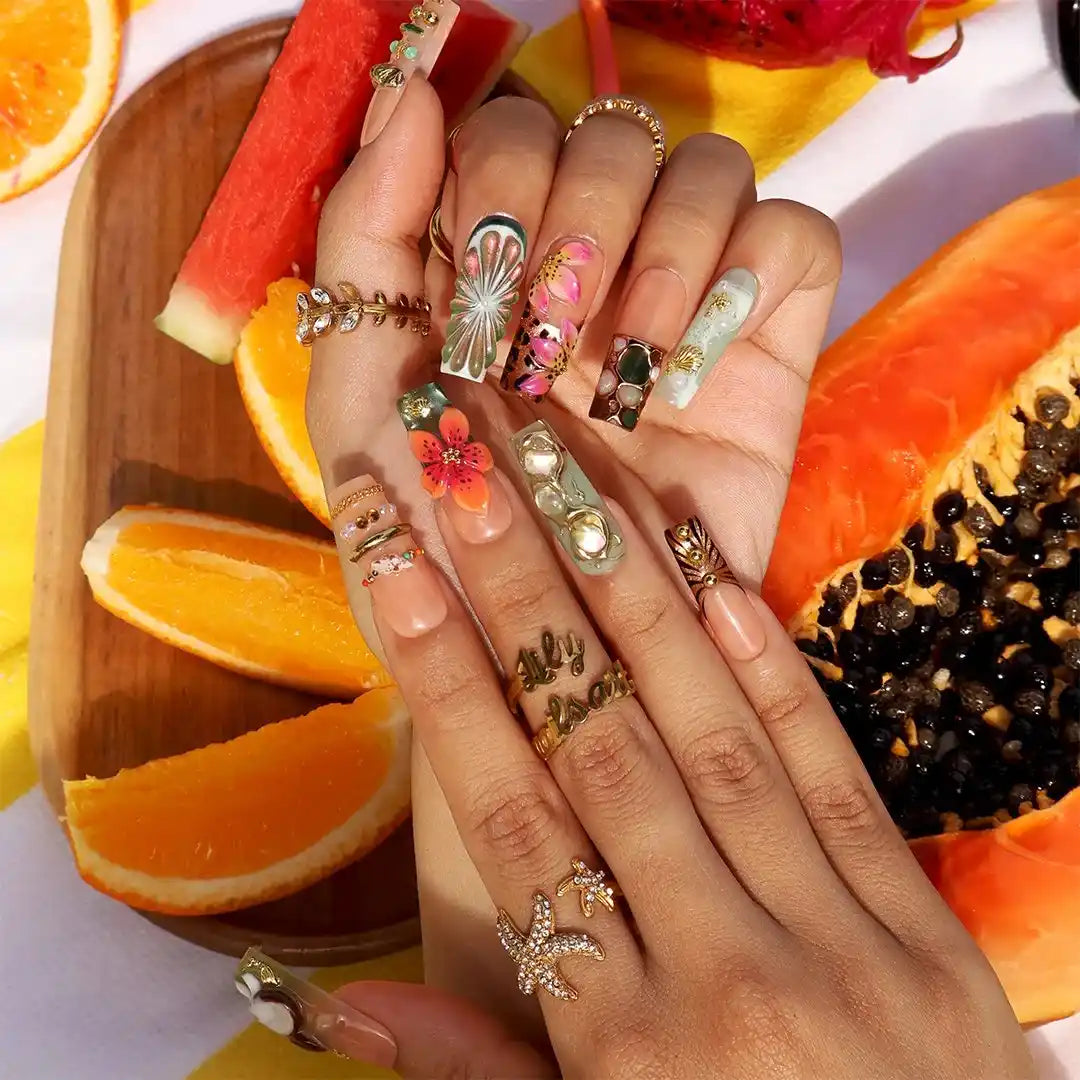 Handmade luxury summer press-on nails with tropical hibiscus, coconut art, 3D floral centerpiece and gold chain embellishments by Lily Nails Art
