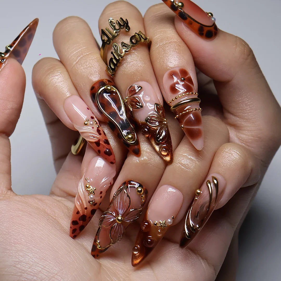 Cognac handmade fall press-on nails — almond set in nude and tortoiseshell brown with gold 3D lilies, wire-work and leopard print