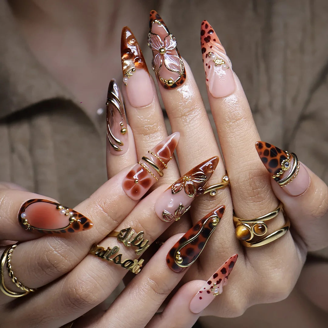 Cognac handmade fall press-on nails — almond set in nude and tortoiseshell brown with gold 3D lilies, wire-work and leopard print