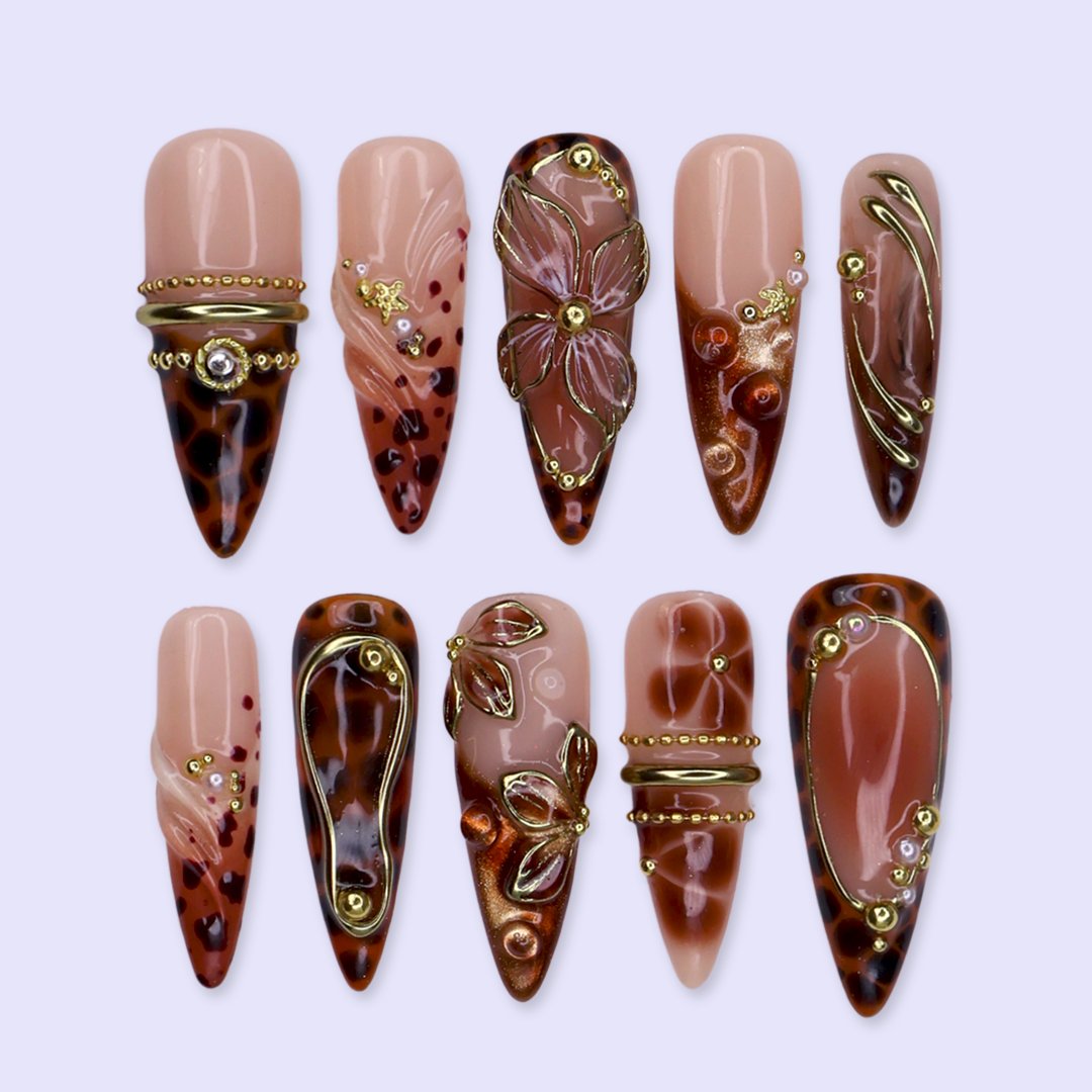 Cognac handmade fall press-on nails — almond set in nude and tortoiseshell brown with gold 3D lilies, wire-work and leopard print