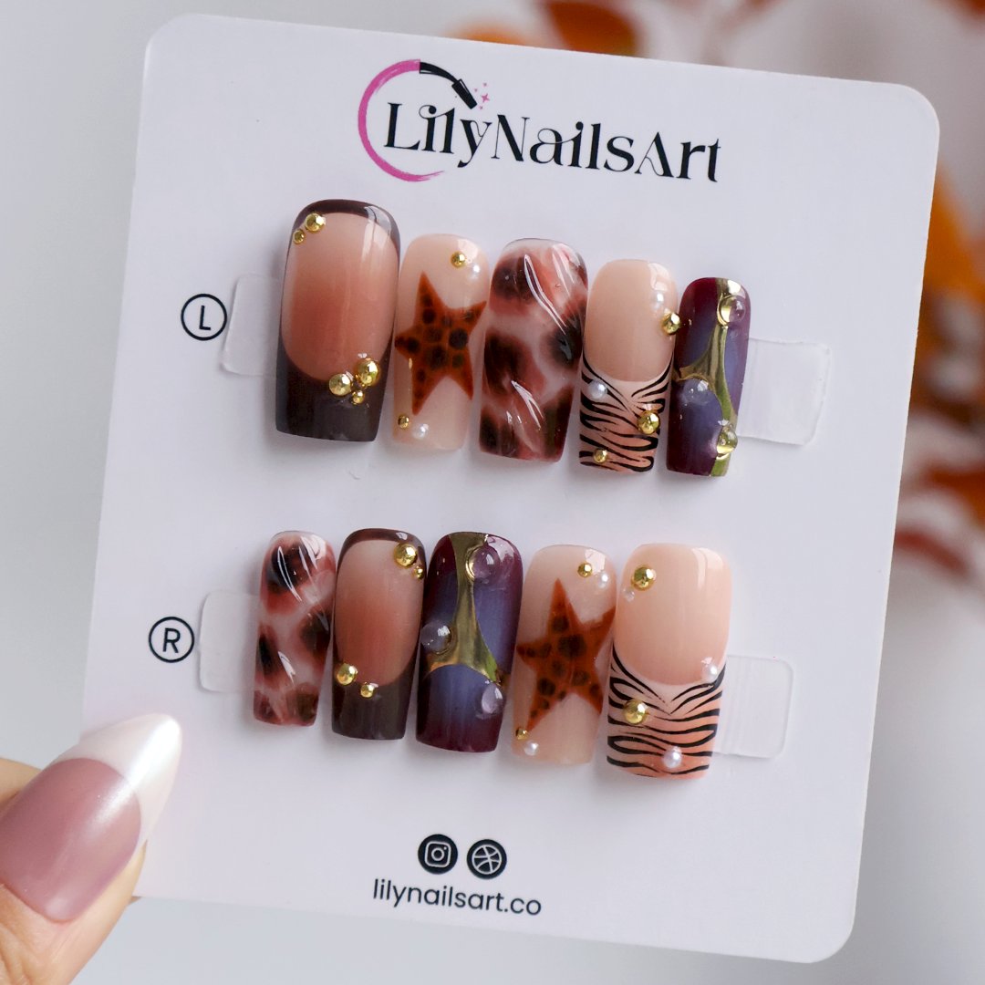 Stargazer handmade fall press-on nails — medium square set in nude, plum-purple and brown with tortoiseshell stars, gold accents and zebra-stripe tips