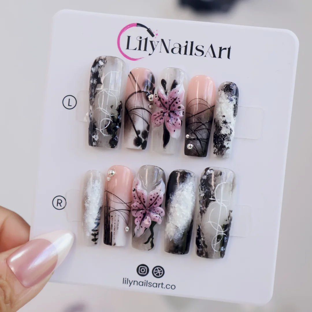 Belladonna gothic press on nails in smoky black and grey over nude with abstract ink marbling, delicate linework and 3D mauve-pink lilies — handmade Halloween press on nails, long square fake nails and gothic nail art.