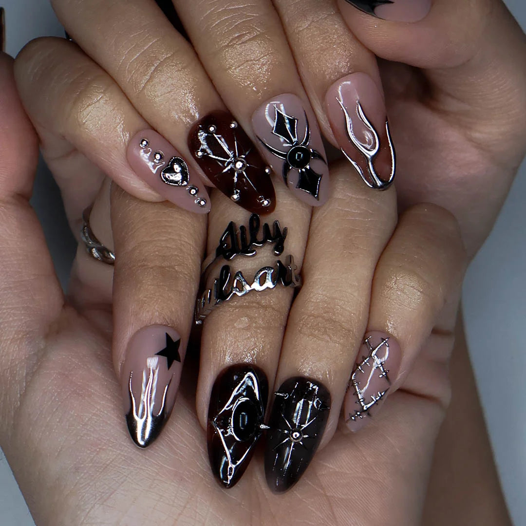 Séance gothic press on nails in nude, tortoiseshell brown and black with chrome silver flames, a 3D spider, ornate cameo, stars, heart charm and stitched details — handmade Halloween press on nails, medium almond fake nails and occult gothic nail art.