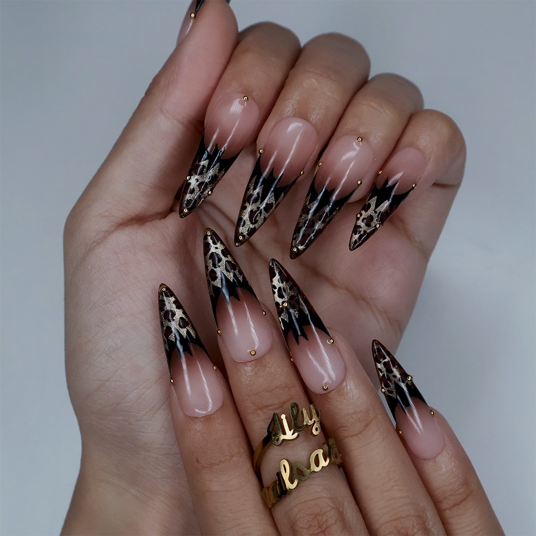 Prowl fall press on nails in nude with black and gold leopard-print French tips and delicate gold bead accents — handmade designer press on nails, long almond fake nails and animal print nail art.