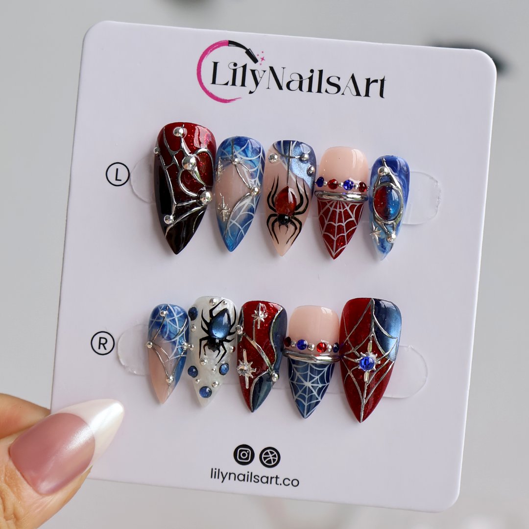 Arachnova handmade gothic Halloween press-on nails — medium stiletto set in blood-red, midnight blue, black and nude with 3D spiders, silver spiderwebs, celestial stars and jewel accents.