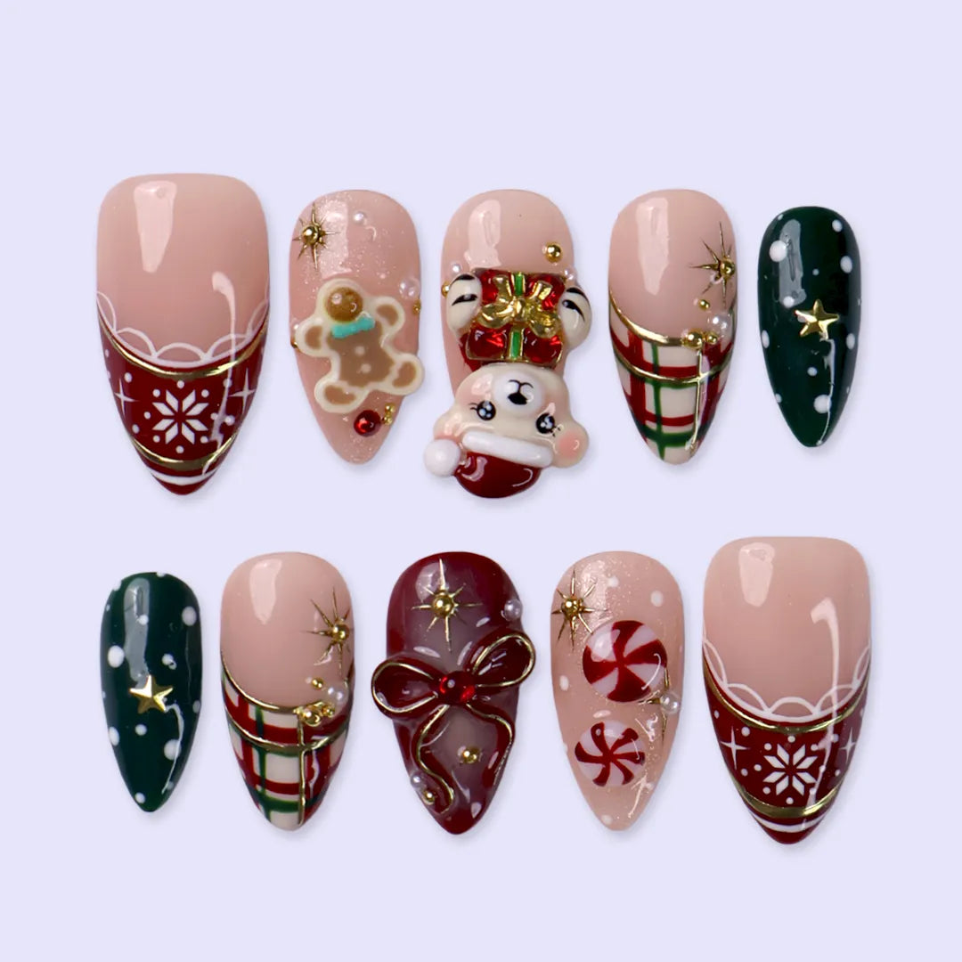 Gingerbread handmade Christmas press-on nails — medium almond set in nude, red and green with a 3D Santa-hat teddy bear, gingerbread man, peppermint candies, red and green plaid, snowflakes, gold stars and bow accents.