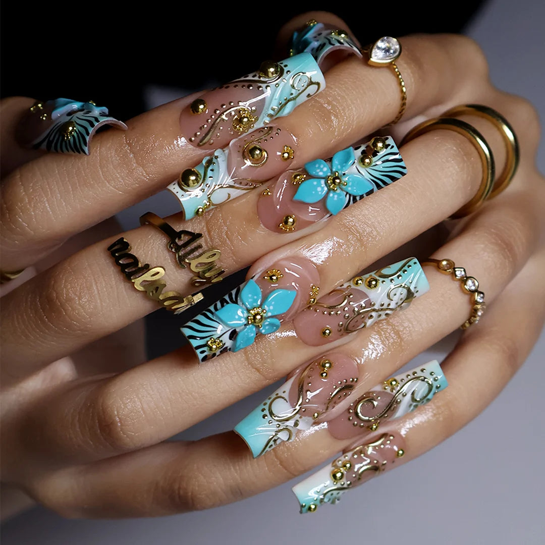 hand model wearing Vermentino handmade press-on nails — maximalist long square set in Tiffany blue with 3D turquoise lilies, gold swirls and leopard print
