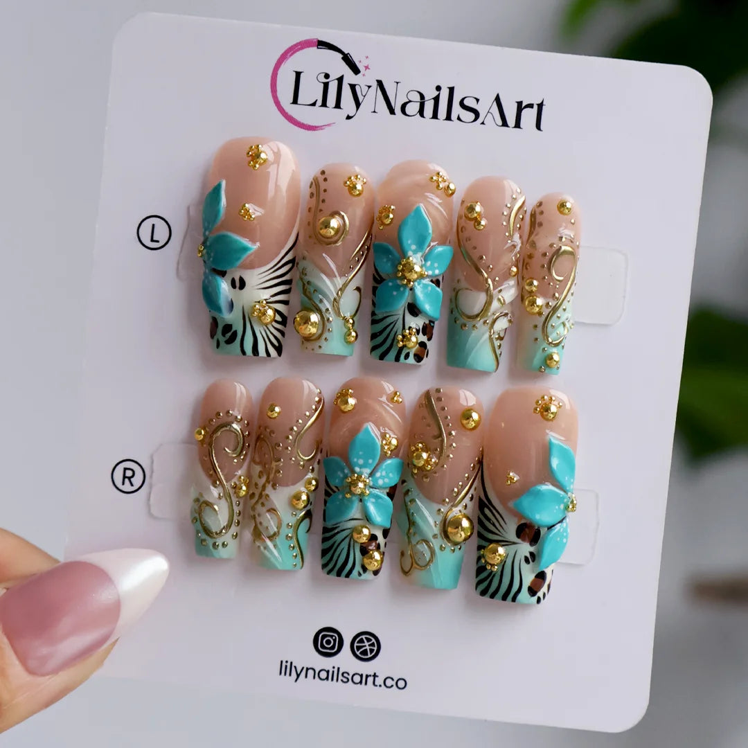 hand model wearing Vermentino handmade press-on nails — maximalist long square set in Tiffany blue with 3D turquoise lilies, gold swirls and leopard print