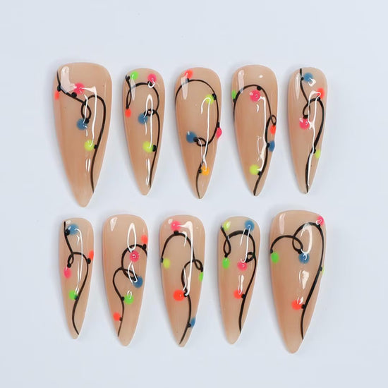 Handmade Christmas press on nails with colorful glowing light string design on stiletto shape — custom holiday nails, luxury fake nails, festive party nail art for Christmas looks and winter events.