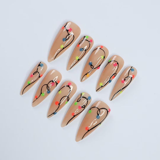Handmade Christmas press on nails with colorful glowing light string design on stiletto shape — custom holiday nails, luxury fake nails, festive party nail art for Christmas looks and winter events.