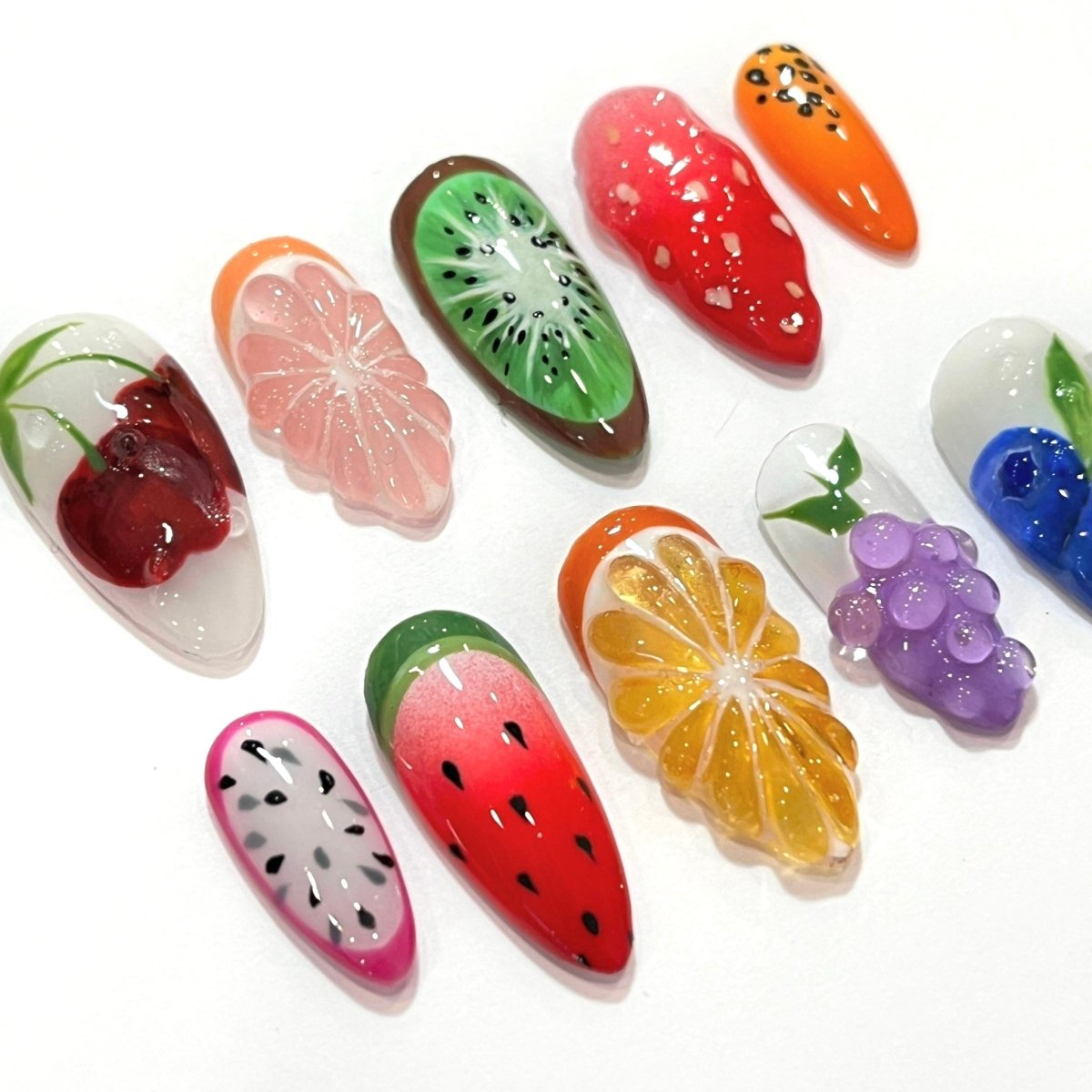 a model wearing 3D fruit press on nails with realistic designs of cherry, grapefruit, kiwi, strawberry, papaya, dragon fruit, watermelon, orange slice, grapes, and blueberries — custom press on nails, luxury handmade nail art, fake nails, false nails, pressons — perfect for summer vibes, fruity themes holiday, vacation ,or a fun gift for her.