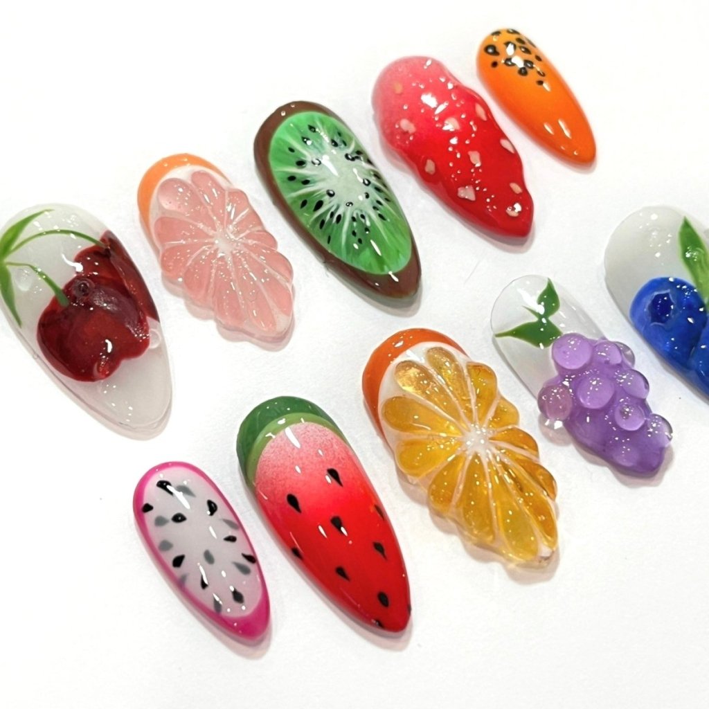 a model wearing 3D fruit press on nails with realistic designs of cherry, grapefruit, kiwi, strawberry, papaya, dragon fruit, watermelon, orange slice, grapes, and blueberries — custom press on nails, luxury handmade nail art, fake nails, false nails, pressons — perfect for summer vibes, fruity themes holiday, vacation ,or a fun gift for her.