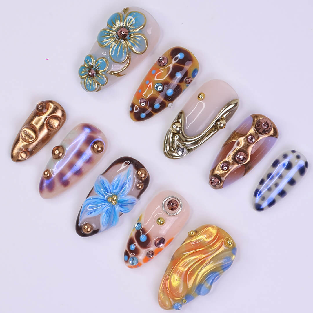 Metallic blue press on nails with sculpted floral accents and bronze chrome — custom almond shape for summer or Y2K looks