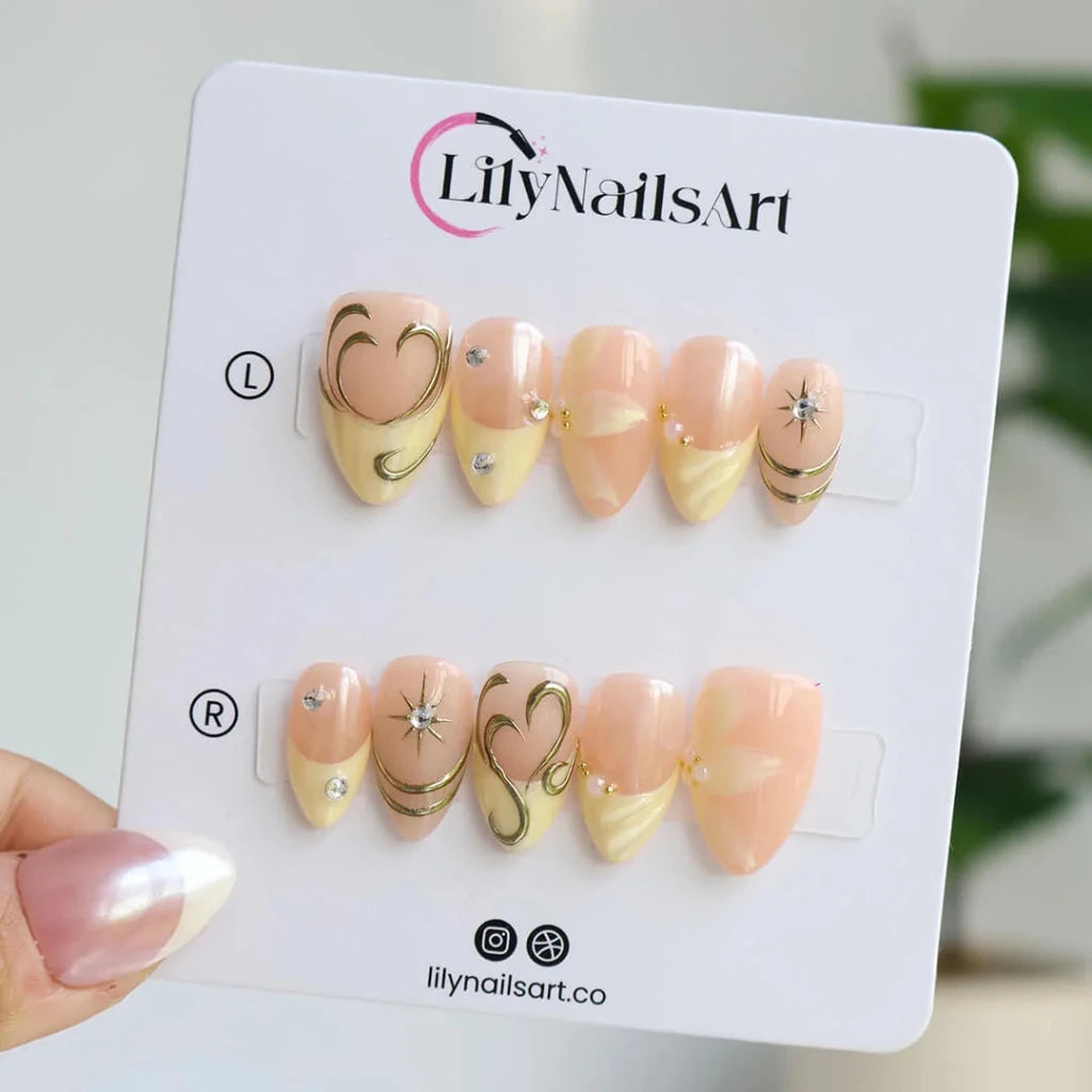 3D gold chrome French tip press on nails with swirl accents, embellished with starburst crystals and white floral details on a nude base — custom press on nails, luxury handmade nail art, fake nails, false nails, pressons — perfect for prom, weddings, and spring events