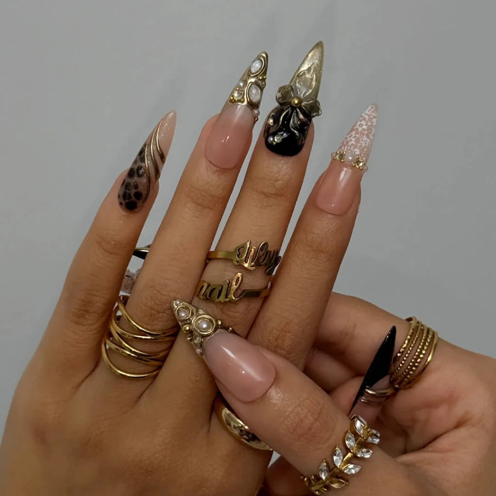 Noir Opulence - black and gold chrome press on nails by LilyNailsArt featuring 3D gold floral bows, lace overlays, leopard print accent, pearls, and crystal embellishments