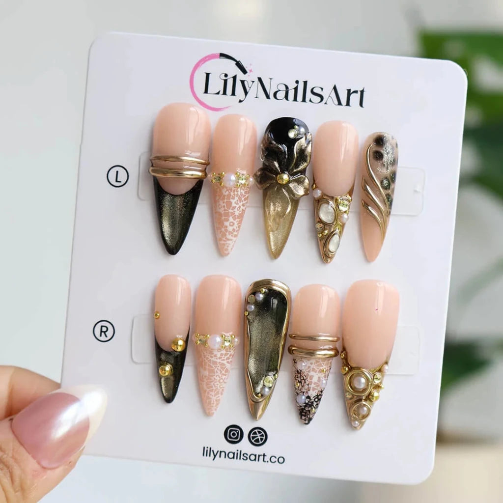 Noir Opulence - black and gold chrome press on nails by LilyNailsArt featuring 3D gold floral bows, lace overlays, leopard print accent, pearls, and crystal embellishments