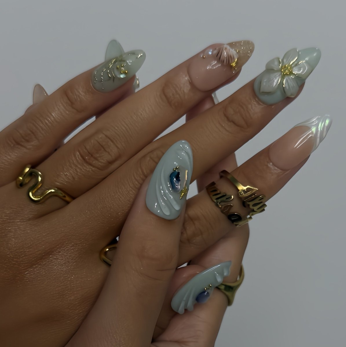 3D seafoam press-on nails with pearl flower accents, gold seashells, and iridescent wave textures — handmade luxury nail art, reusable and custom-sized false nails in a soft pastel green and nude colorway — perfect for beach weddings, summer travel, or romantic coastal looks.