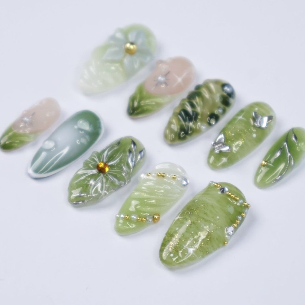 Awaken the spirit of the forest with Sylvara, a graceful press-on nail set woven with misty greens, sparkling silver details, and sculpted 3D florals. Blending soft gradients, leafy textures, and dewdrop-like accents, Sylvara captures the quiet magic of nature’s hidden groves. 🌿