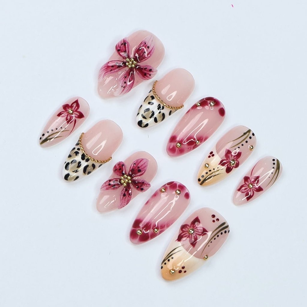 Handmade spring press-on nails featuring delicate 3D sakura flowers, leopard print French tips, and gold accents. Designed in a soft pink color palette with a glossy finish, perfect for floral nail lovers, holiday nails, vacation-ready nails, and birthday nail sets.