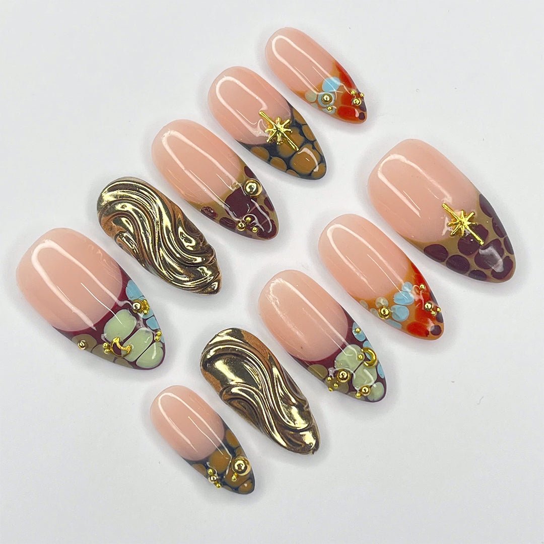 Luxury designer press-on nails featuring nude tones with abstract gold chrome accents, gemstone embellishments, and intricate mosaic details. These high-end, reusable, and salon-quality press-ons offer a premium alternative to brands like Kiss and Glamour Press-On Nails. Perfect for those seeking long-lasting, artistic nail designs without the hassle of a salon visit. Shop custom, handcrafted press-on nails for a chic, trendy look.