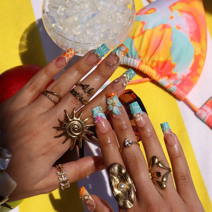 Handmade summer press-on nails with ocean art featuring seahorse, starfish, seashells, teal waves and gold swirl embellishments by Lily Nails Art