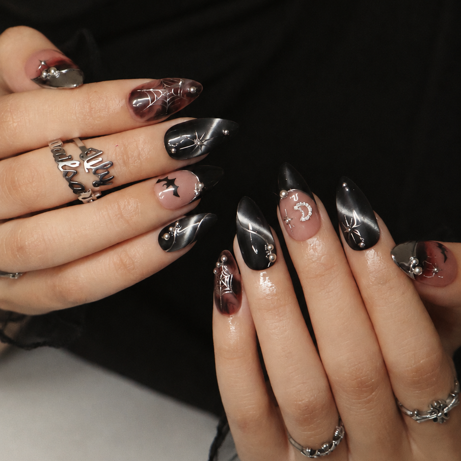 Batwing handmade gothic Halloween press-on nails — medium almond set in nude, black cat-eye and smoky brown with silver chrome tips, bats, rhinestone crescent moon and silver spiderwebs.