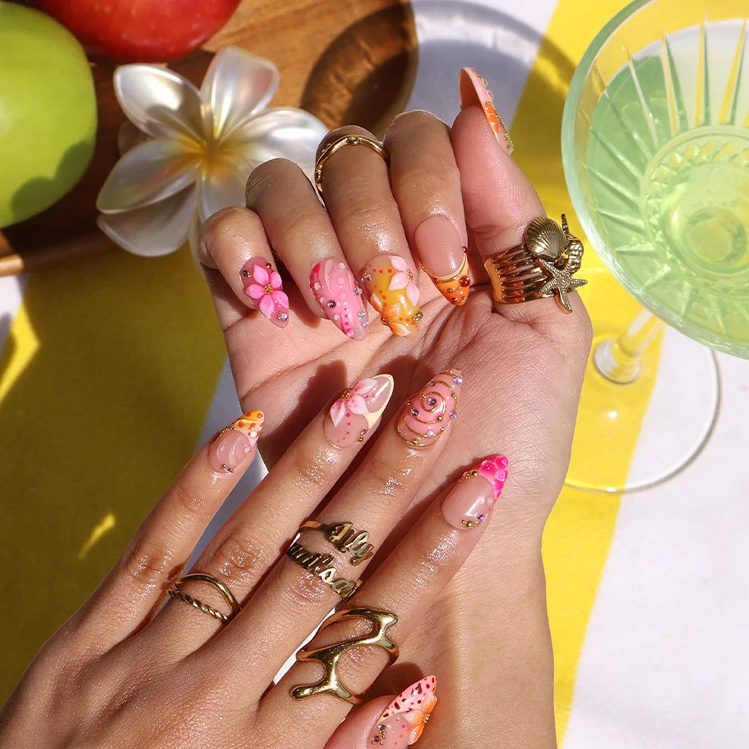 Handmade summer press-on nails with coral pink blooms, 3D floral centerpiece, leopard dots and gold spiral details by Lily Nails Art