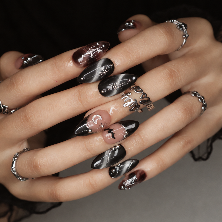 Batwing handmade gothic Halloween press-on nails — medium almond set in nude, black cat-eye and smoky brown with silver chrome tips, bats, rhinestone crescent moon and silver spiderwebs.