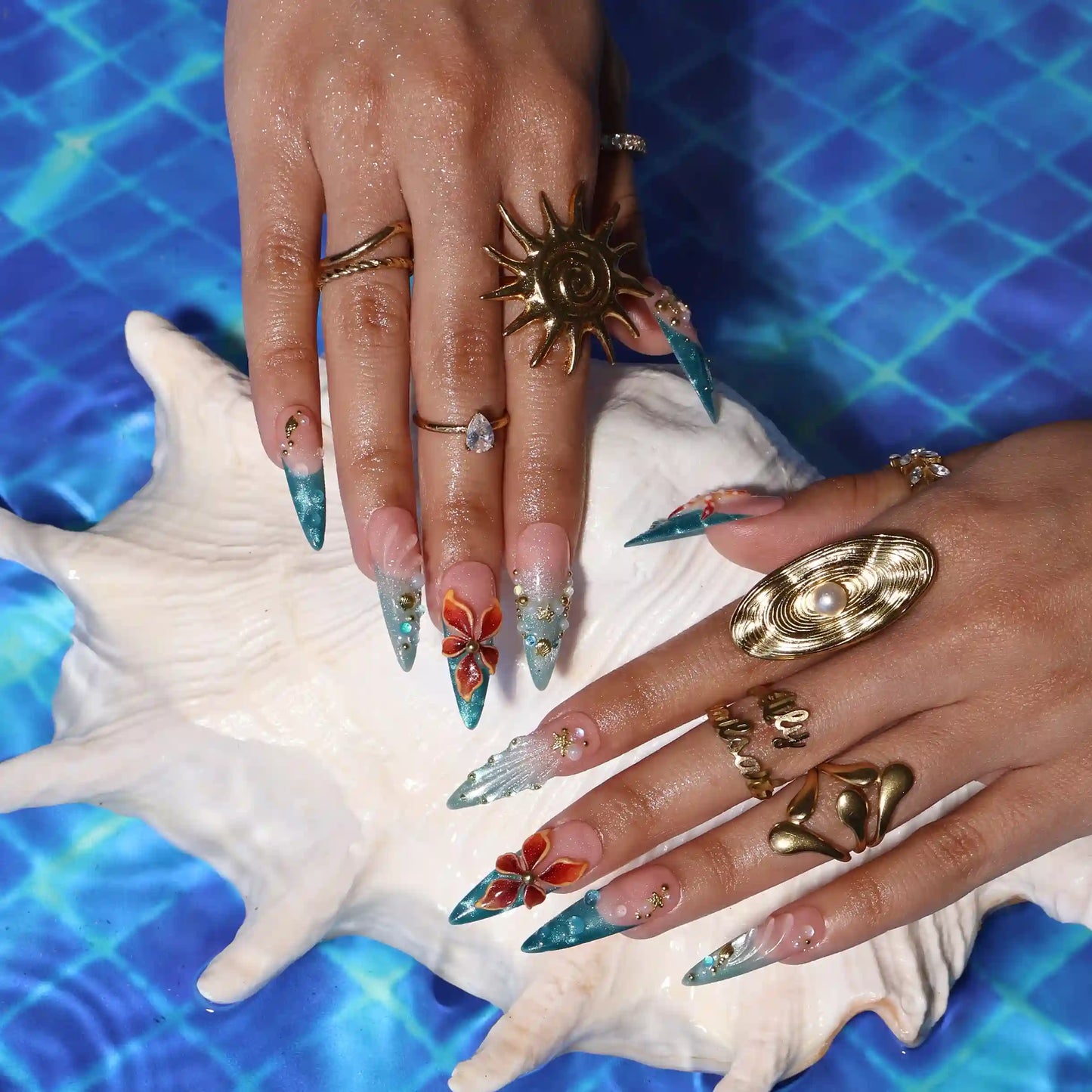 Handmade summer stiletto press-on nails with deep teal ocean base, amber bloom, starfish, gold seahorse charm and iridescent crystal embellishments by Lily Nails Art