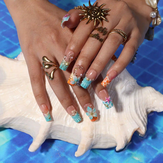 Handmade summer press-on nails with ocean art featuring seahorse, starfish, seashells, teal waves and gold swirl embellishments by Lily Nails Art