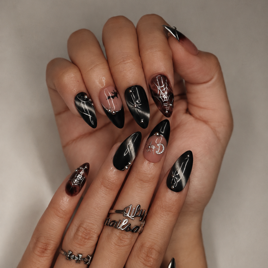Batwing handmade gothic Halloween press-on nails — medium almond set in nude, black cat-eye and smoky brown with silver chrome tips, bats, rhinestone crescent moon and silver spiderwebs.