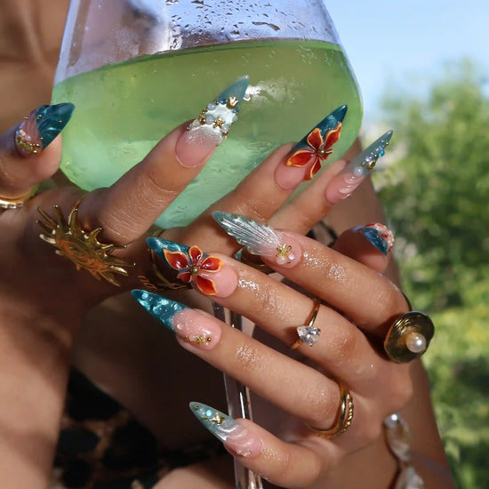 Handmade summer stiletto press-on nails with deep teal ocean base, amber bloom, starfish, gold seahorse charm and iridescent crystal embellishments by Lily Nails Art