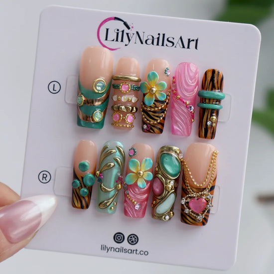 a set of pink & tiffaniy handmade press-on nails — maximalist long square set with gold tiger print, cat-eye gems, 3D daisies and heart charm