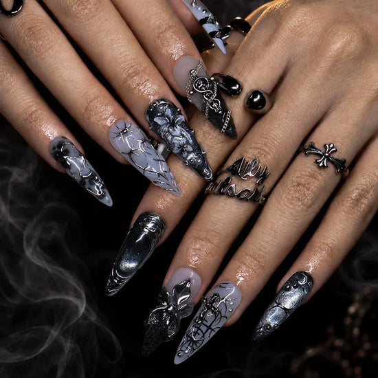 Grimoire gothic press on nails in black, chrome and grey with silver crosses, chains, snake, spiderweb details and 3D silver lilies — handmade Halloween press on nails, long almond fake nails and gothic nail art.