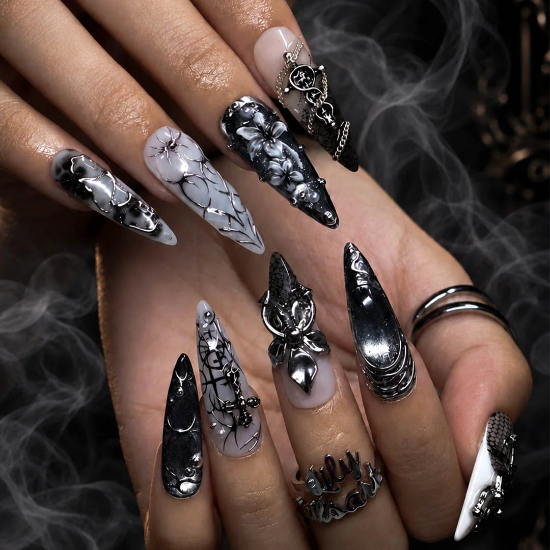 Grimoire gothic press on nails in black, chrome and grey with silver crosses, chains, snake, spiderweb details and 3D silver lilies — handmade Halloween press on nails, long almond fake nails and gothic nail art.