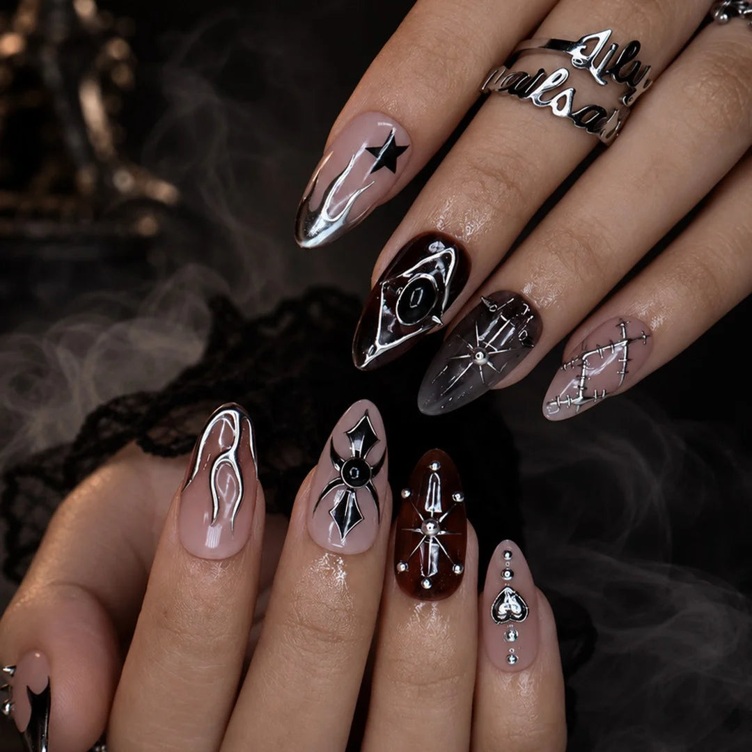 Séance gothic press on nails in nude, tortoiseshell brown and black with chrome silver flames, a 3D spider, ornate cameo, stars, heart charm and stitched details — handmade Halloween press on nails, medium almond fake nails and occult gothic nail art.