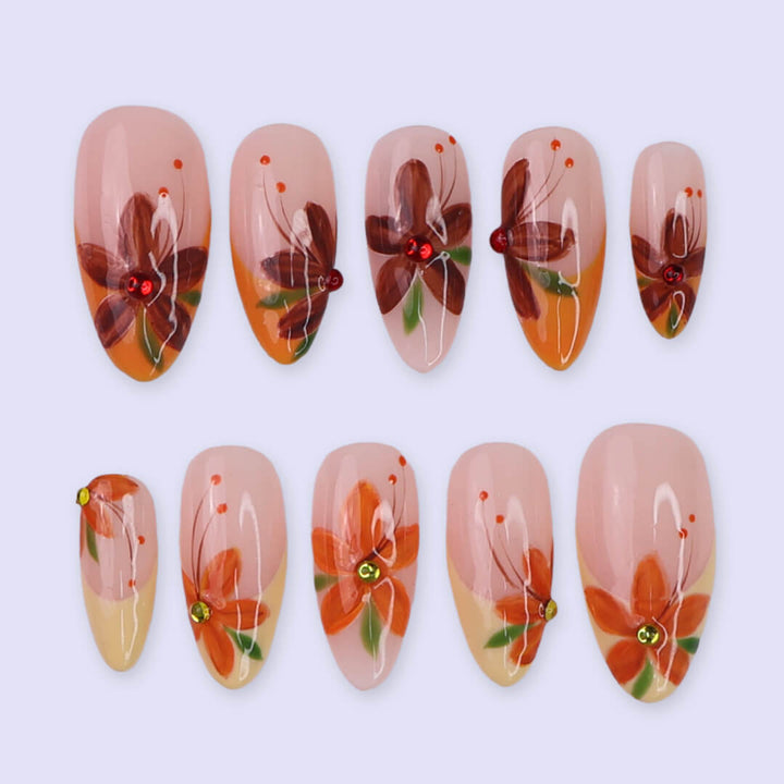 Autumn floral press on nails with hand-painted orange and red flowers, gem accents, and nude-to-warm gradient bases — custom made medium almond nails, reusable luxury nail art — perfect for fall, autumn looks, or romantic seasonal style.