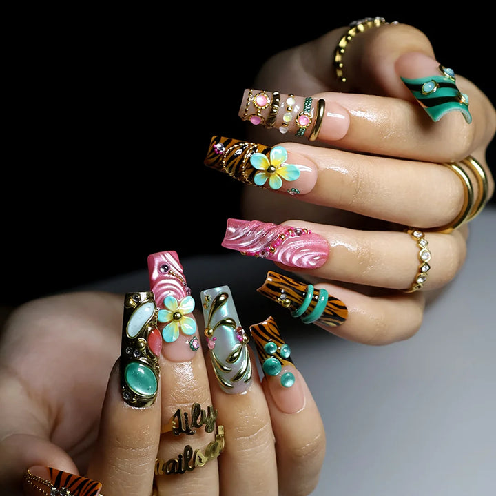 hand model wearing pink & tiffaniy handmade press-on nails — maximalist long square set with gold tiger print, cat-eye gems, 3D daisies and heart charm
