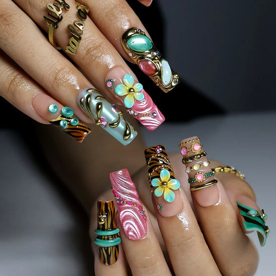 hand model wearing pink & tiffaniy handmade press-on nails — maximalist long square set with gold tiger print, cat-eye gems, 3D daisies and heart charm