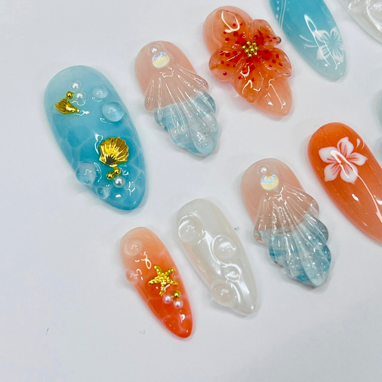 Handmade Tropical Ocean Press-On Nails – vibrant blue and coral tones with 3D seashells, flowers, starfish, and pearl accents. Perfect for  summer holidays, birthdays, vacations, or as a unique gift for her.