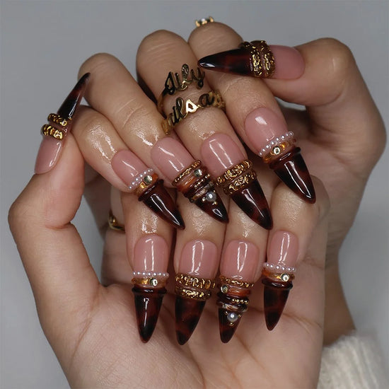Bourbon handmade fall press-on nails — long almond set in nude fading into deep tortoiseshell brown with textured gold bands, delicate pearls and sparkling gemstone accents.
