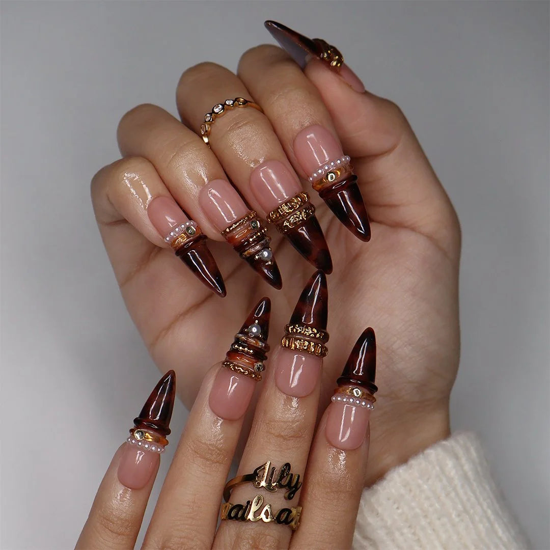 Bourbon handmade fall press-on nails — long almond set in nude fading into deep tortoiseshell brown with textured gold bands, delicate pearls and sparkling gemstone accents.