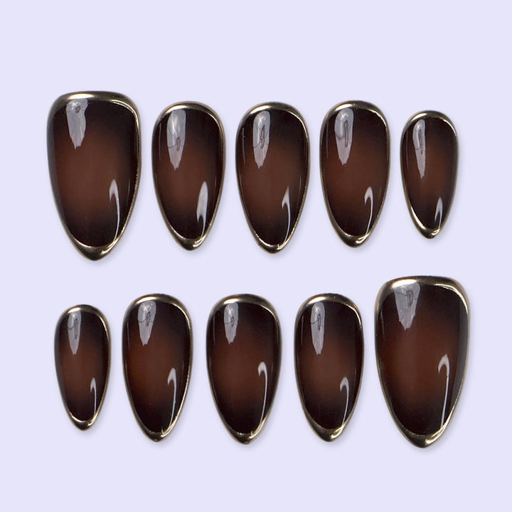 Espresso handmade fall press-on nails — almond set in glossy translucent chocolate-brown with liquid gold chrome mirror borders and a minimalist luxury finish
