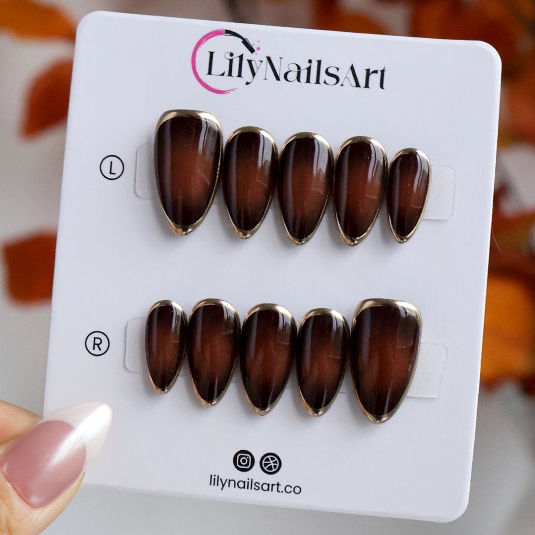 Espresso handmade fall press-on nails — almond set in glossy translucent chocolate-brown with liquid gold chrome mirror borders and a minimalist luxury finish